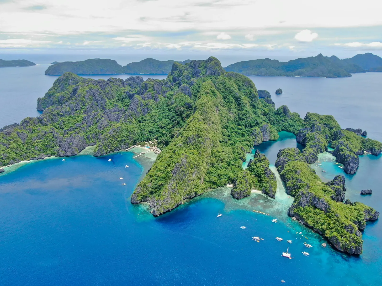 Limestone islands rising from blue water in El Nido, Philippines